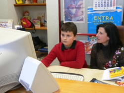 Un niño y su madre consultan juntos el ordenador.