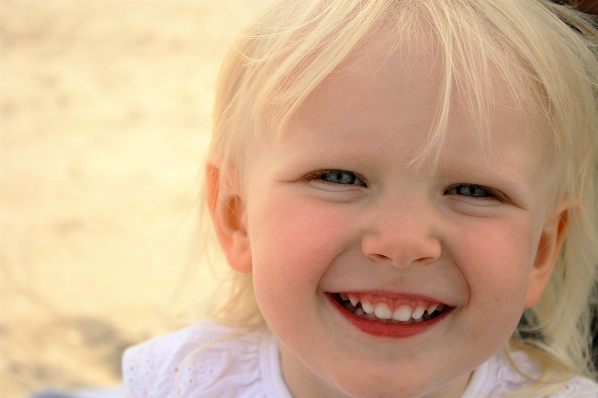 Cara de felicidad de una niña rubia muy sonriente
