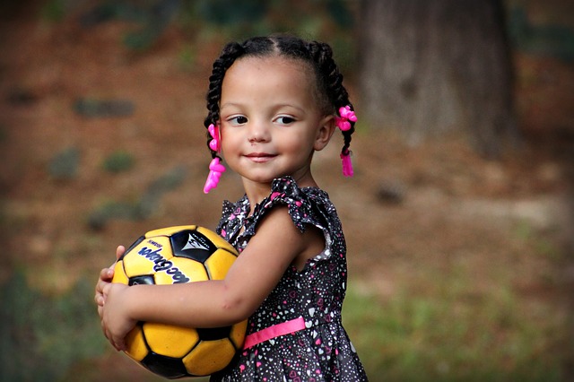 niña sonriente con un balón de fútbol