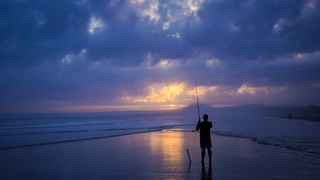 Persona pescando en la playa