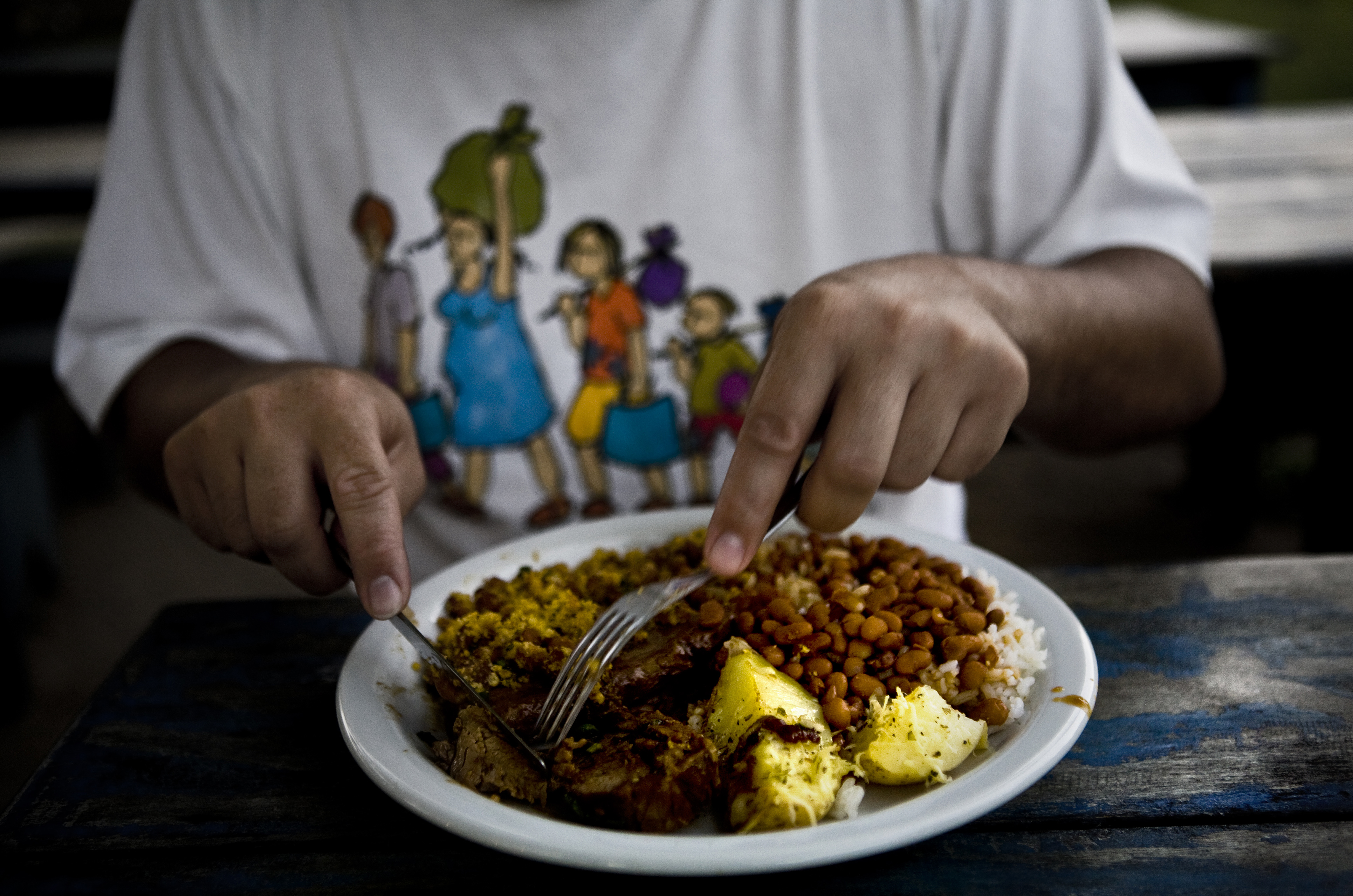 Comiendo Persona cogiendo comida de su plato con el cuchillo y el tenedor.