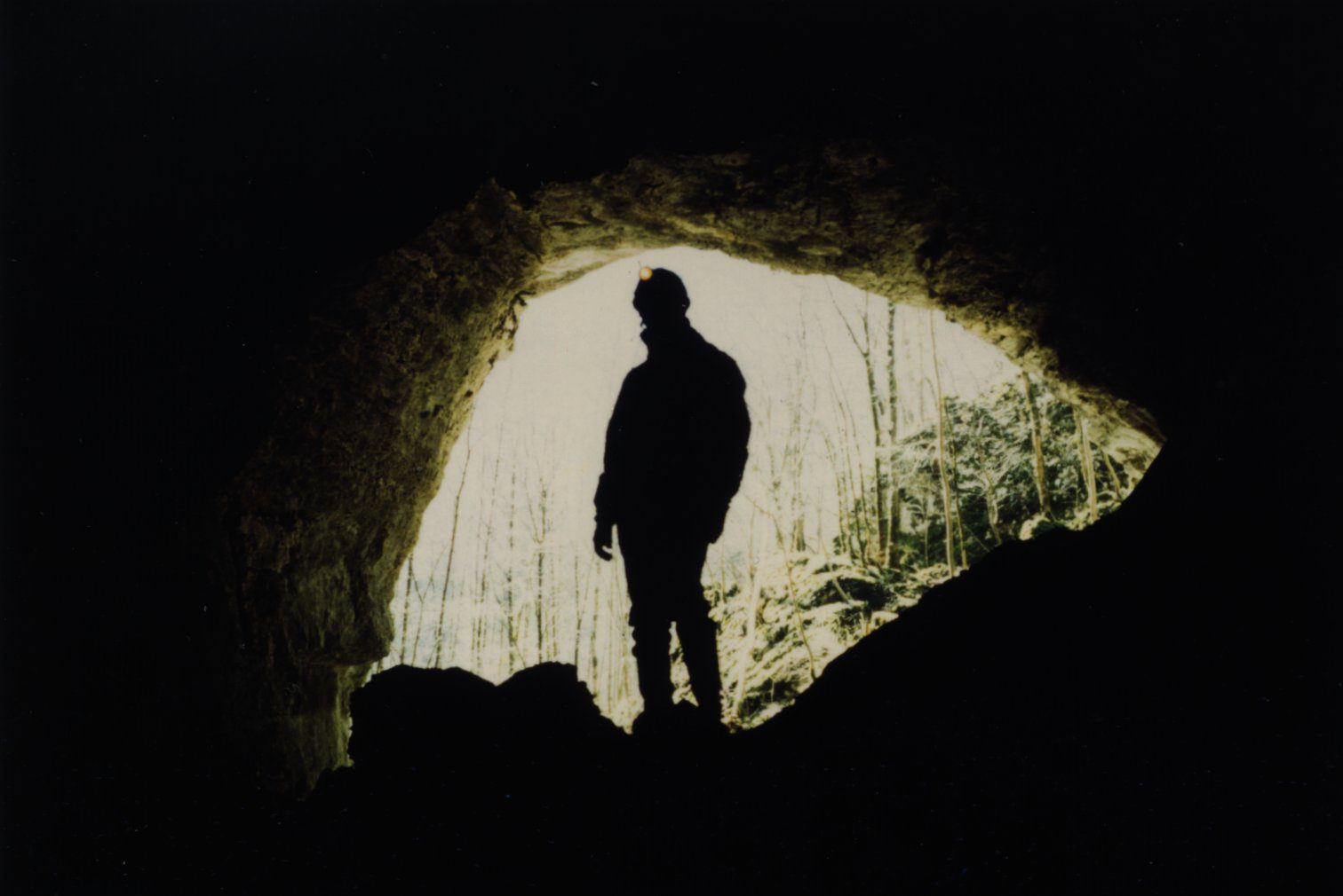 Grotte des Faux-Monnayeurs, Suiza. Entrada a una cueva con un espeleólogo al fondo.