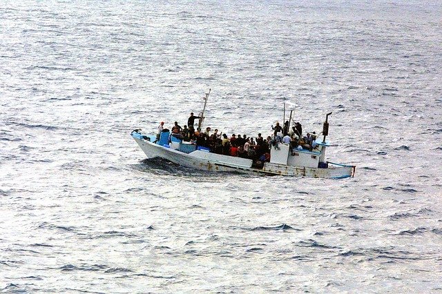 En la imagen aparece un barco en alta mar con varios inmigrantes.