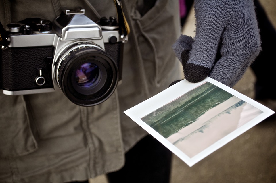 Imagen de una persona con una cámara y una fotografía que ilustra el turismo 
