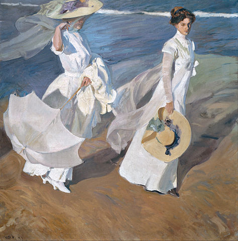 Dos señoras vestidas de blanco pasean por la playa