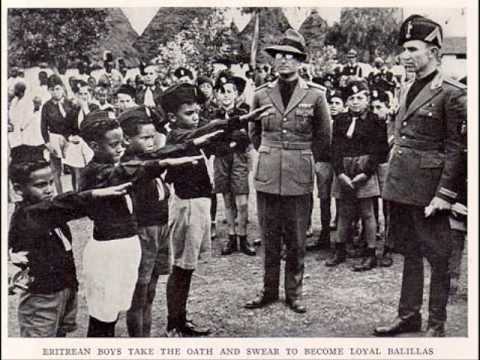 Niños eritreos haciendo el saludo fascista ante oficiales italianos Niños eritreos haciendo el saludo fascista ante oficiales italianos
