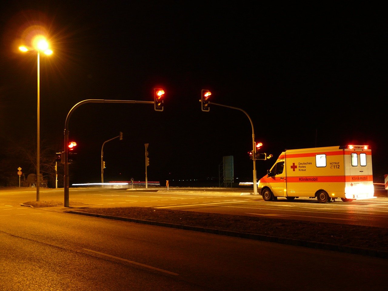 Una ambulancia con las sirenas encendidas llega a un semáforo en rojo 