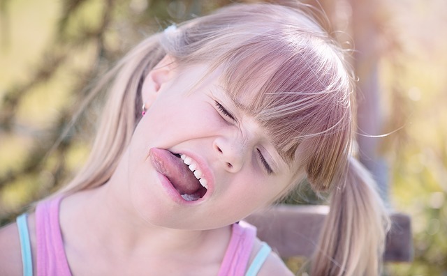 Una niña saca la lengua