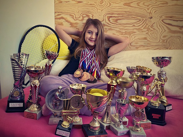 Chica rodeada de trofeos y medallas
