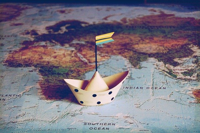Mapa del mundo con un barco de papel encima