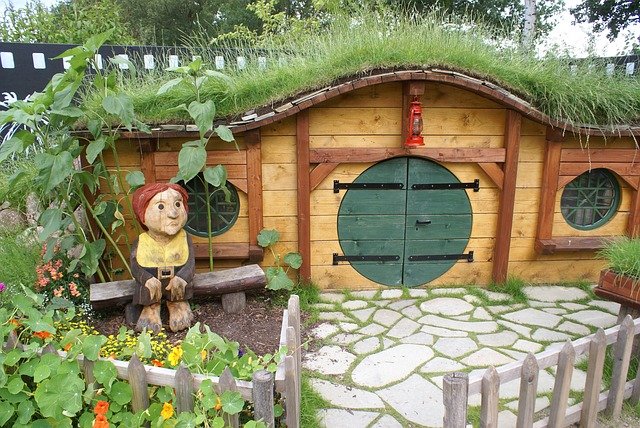 Casa de madera con un hobbit a la entrada.