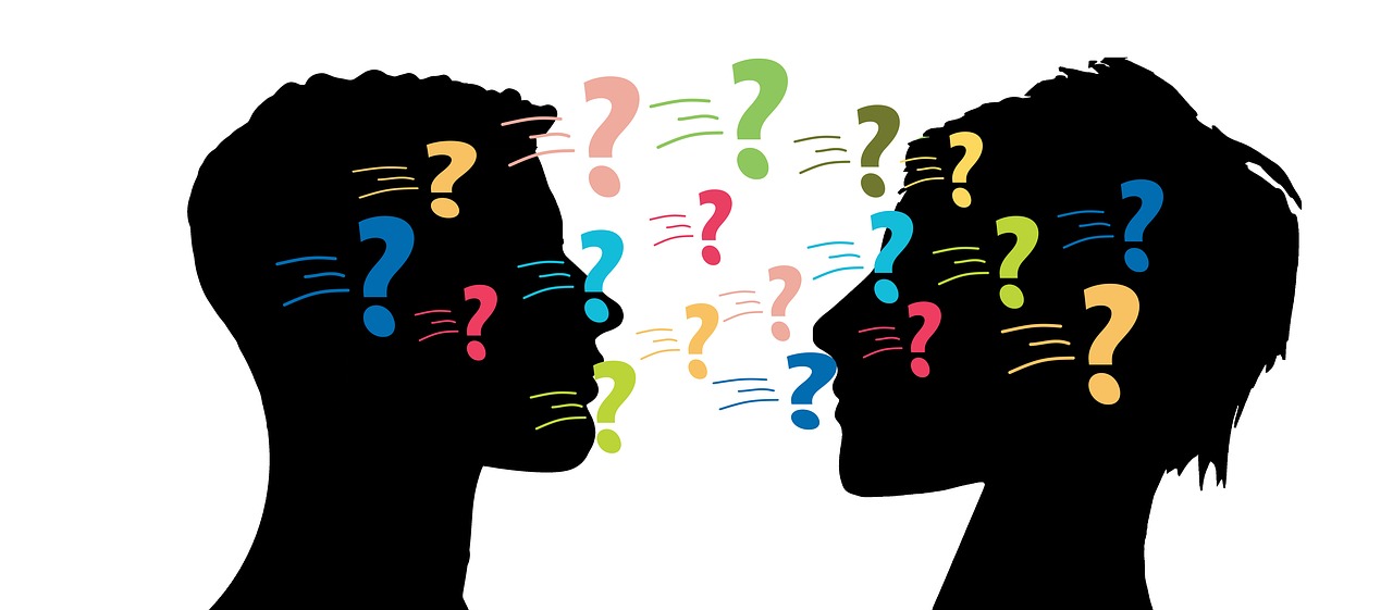 Siluetas de dos personas en actitud dialogante acompañadas de signos de interrogación en color