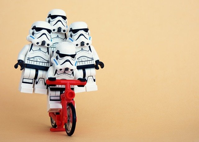 Robots-soldado coordinados Cuatro muñecos de robots-soldado de "La guerra de las galaxias" se coordinan para montar una sola bicicleta entre todos.