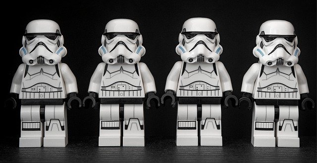 Yuxtaposición Cuatro muñecos de robots-soldado de "La guerra de las galaxias" formados uno al lado del otro.
