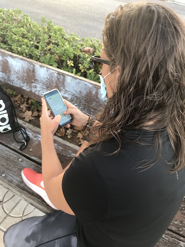 Una chica sentada en un banco enviando un whatssap