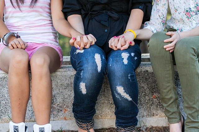 Unas niñas se agarran las manos expresando amistad